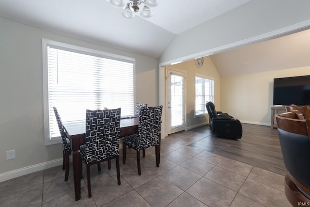 tiled dining room featuring lofted ceiling and a healthy amount of sunlight