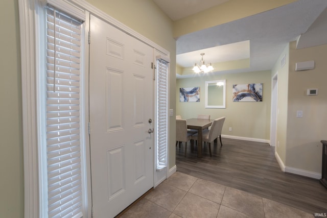 tiled entryway with an inviting chandelier