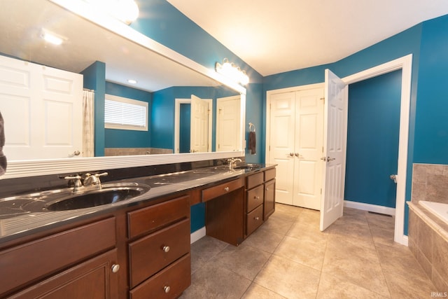 bathroom featuring tile patterned flooring, vanity, and a relaxing tiled tub