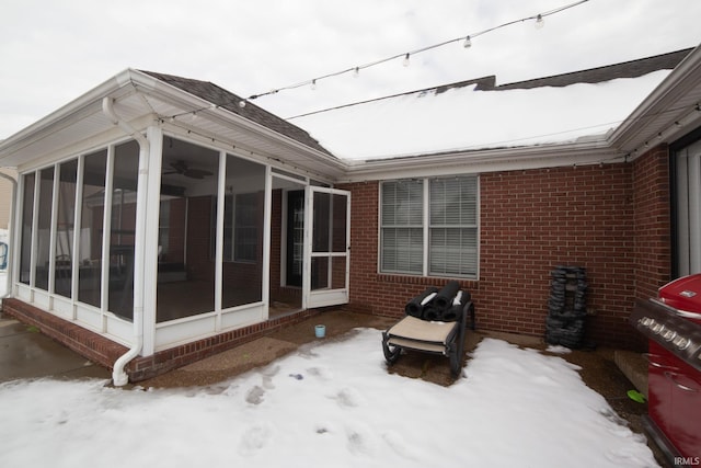 snow covered property featuring a sunroom