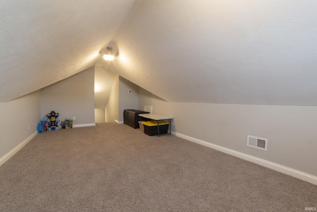 bonus room featuring lofted ceiling, carpet floors, and a textured ceiling