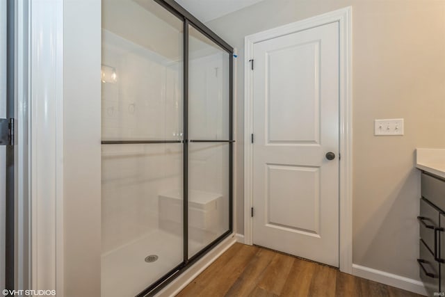 bathroom featuring an enclosed shower, vanity, and wood-type flooring