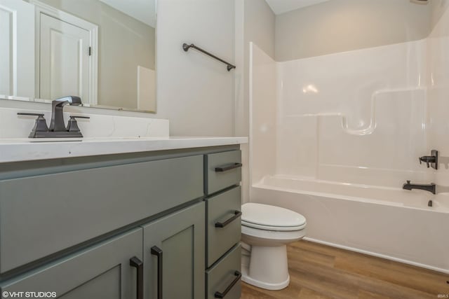 full bathroom featuring toilet, tub / shower combination, wood-type flooring, and vanity