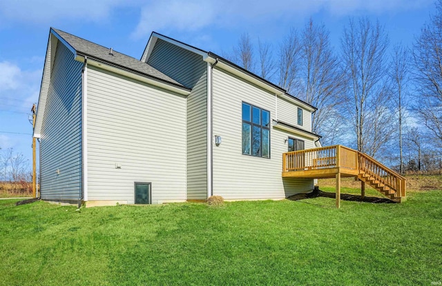 rear view of property featuring a wooden deck and a lawn