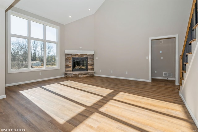 unfurnished living room featuring high vaulted ceiling, hardwood / wood-style floors, and a fireplace