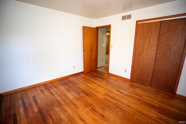 unfurnished bedroom featuring hardwood / wood-style floors and a closet