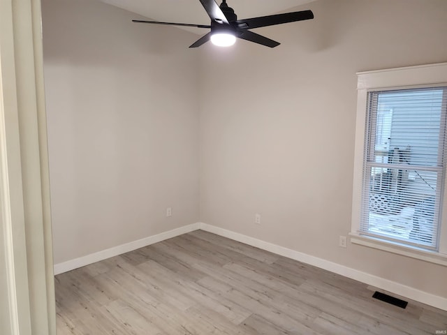 empty room featuring ceiling fan, a wealth of natural light, and light hardwood / wood-style flooring