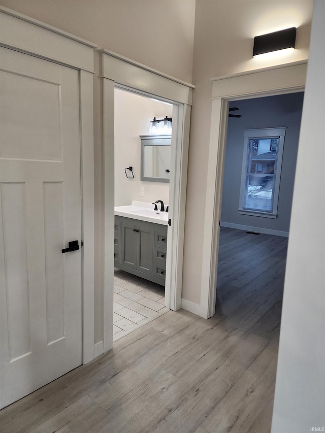 corridor featuring light hardwood / wood-style floors and sink