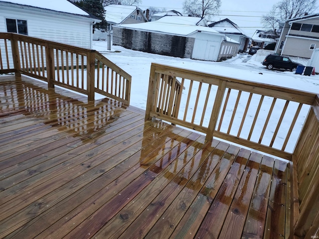 snow covered deck with a shed