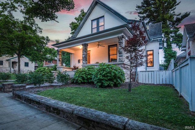 view of front facade featuring covered porch and a lawn