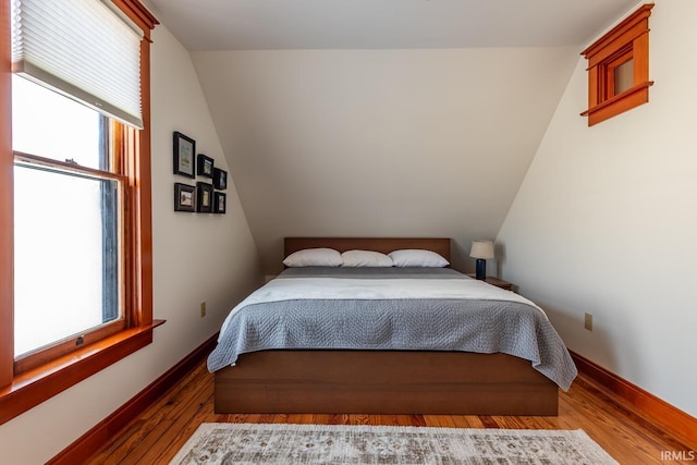 bedroom featuring lofted ceiling and hardwood / wood-style floors