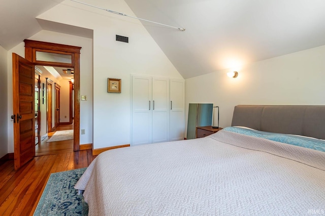 bedroom featuring dark wood-type flooring and lofted ceiling