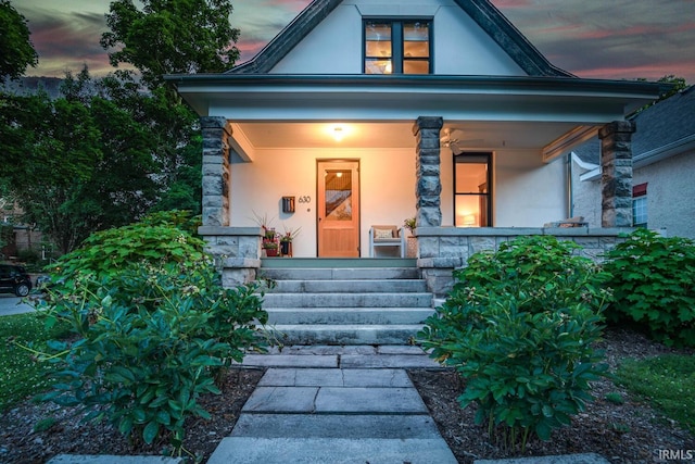 exterior entry at dusk featuring covered porch