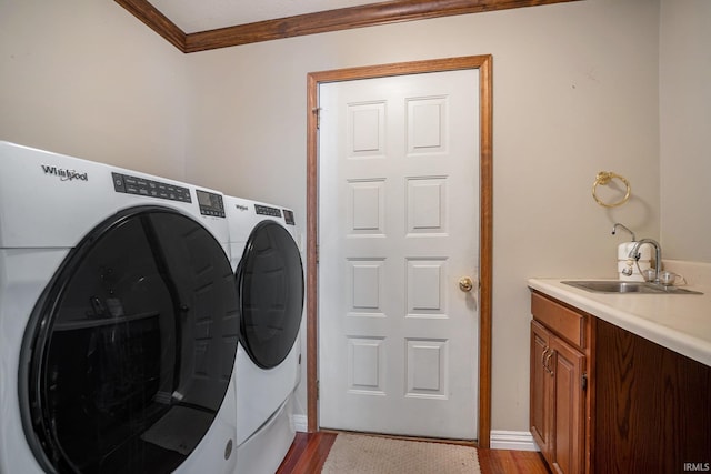 laundry area featuring sink, independent washer and dryer, ornamental molding, and light hardwood / wood-style flooring