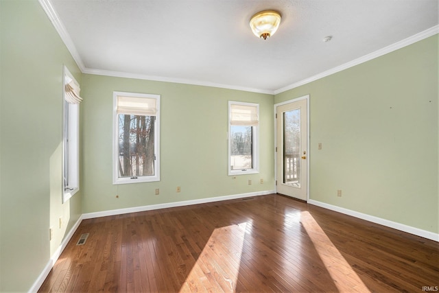 spare room with a healthy amount of sunlight, dark wood-type flooring, and crown molding