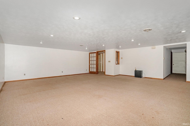 carpeted spare room featuring a textured ceiling