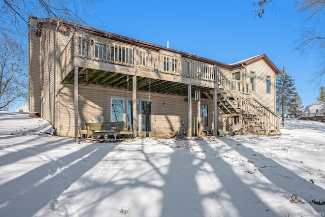 snow covered rear of property featuring a wooden deck