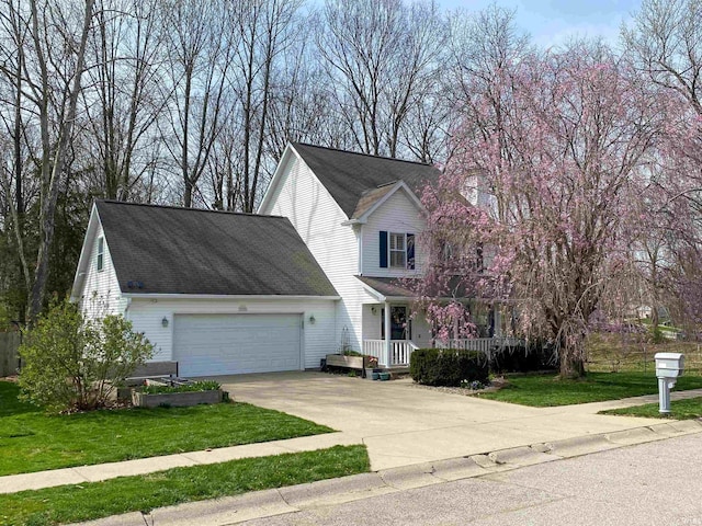 view of front facade featuring a front yard, a porch, and a garage