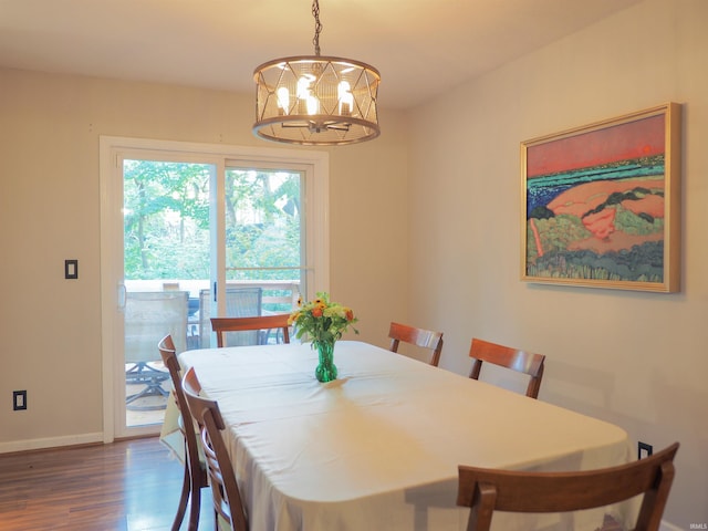 dining space with dark hardwood / wood-style flooring and a notable chandelier