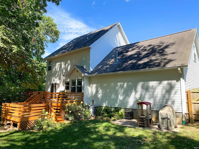 back of property featuring a wooden deck and a lawn