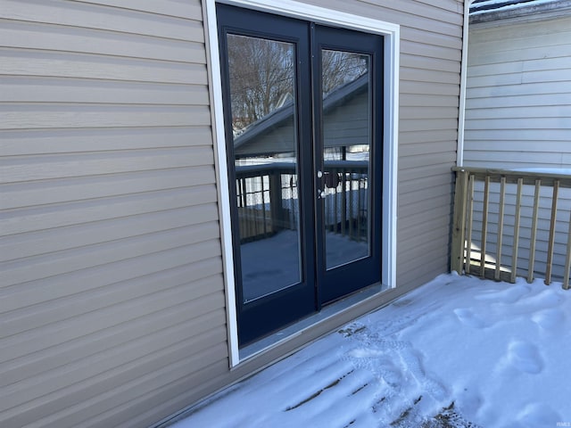 snow covered property entrance featuring french doors