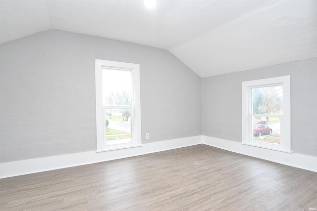 additional living space featuring lofted ceiling and hardwood / wood-style flooring