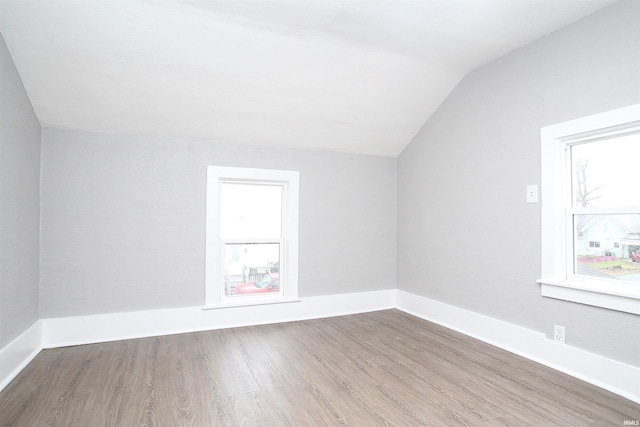 additional living space featuring vaulted ceiling and hardwood / wood-style flooring