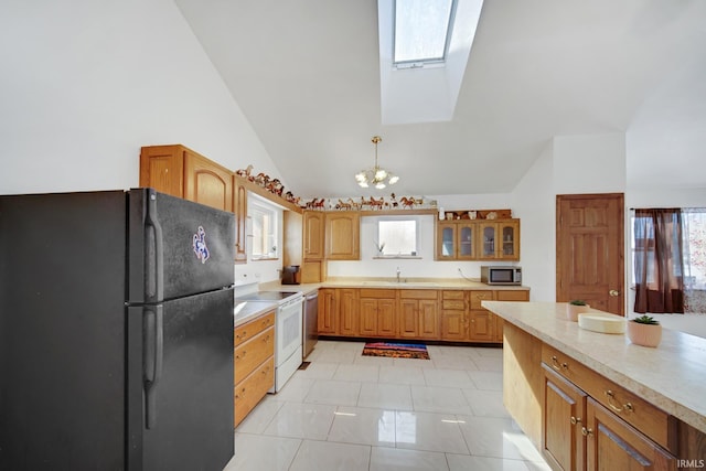 kitchen featuring electric stove, a notable chandelier, black fridge, sink, and light tile patterned floors