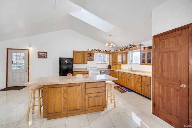 kitchen with vaulted ceiling with skylight, a center island, an inviting chandelier, a kitchen breakfast bar, and electric range