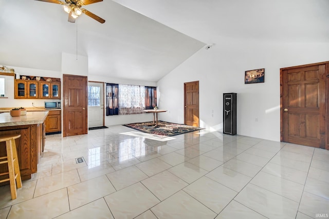 living room with ceiling fan and high vaulted ceiling