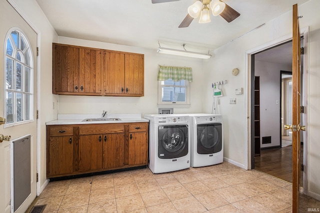 laundry area featuring ceiling fan, washing machine and dryer, sink, light tile patterned floors, and cabinets