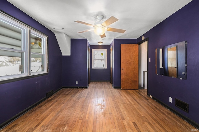 spare room featuring dark wood-type flooring, ceiling fan, and a wealth of natural light