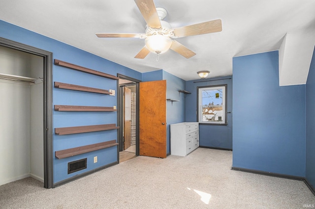 unfurnished bedroom featuring ceiling fan, a closet, and light carpet