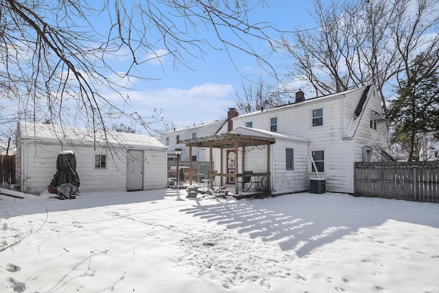 snow covered property featuring central air condition unit and a pergola