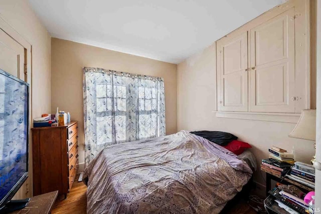 bedroom with dark hardwood / wood-style flooring