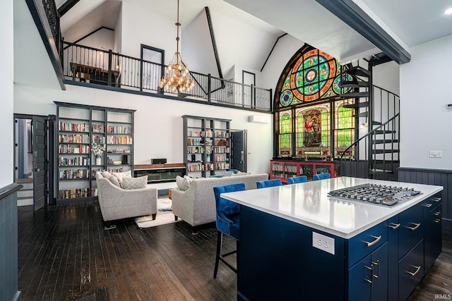 kitchen with stainless steel gas stovetop, blue cabinetry, a kitchen breakfast bar, dark wood-type flooring, and a kitchen island