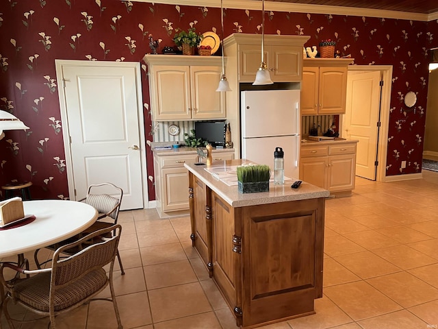 kitchen with decorative light fixtures, light tile patterned floors, white fridge, and a kitchen island