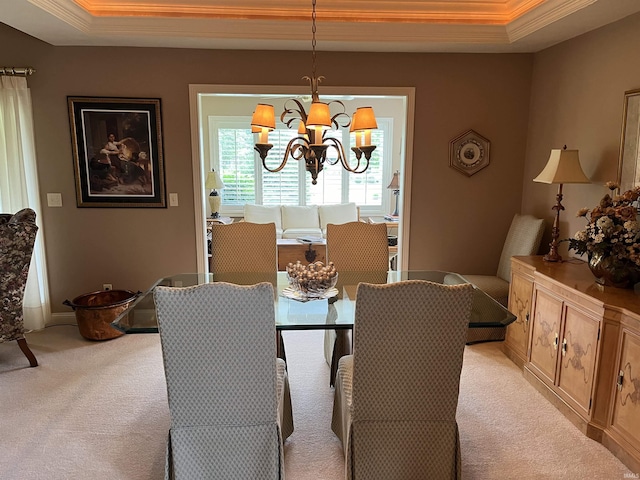 dining space featuring light colored carpet, a tray ceiling, and a chandelier