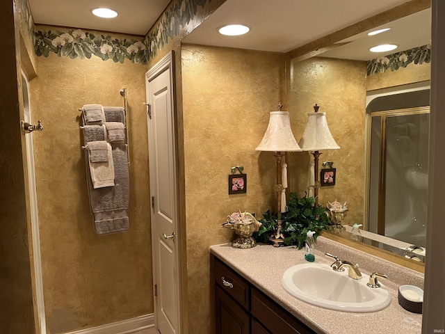 bathroom featuring walk in shower and vanity