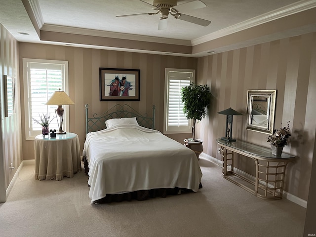 carpeted bedroom with a raised ceiling, ceiling fan, and ornamental molding