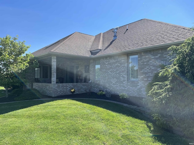 rear view of property featuring a lawn