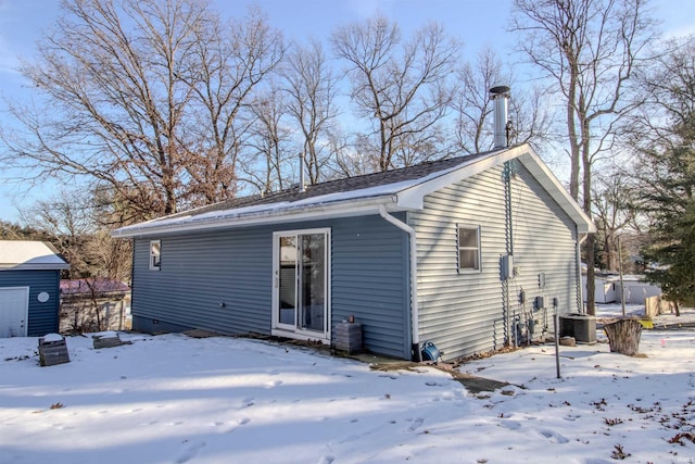 snow covered rear of property featuring cooling unit