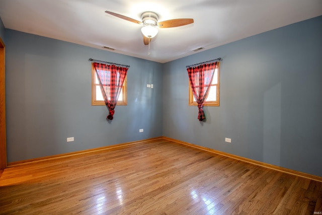 empty room with ceiling fan and light hardwood / wood-style floors