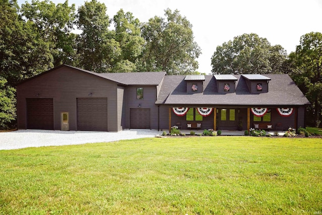 view of front of property with a garage, a front lawn, and covered porch