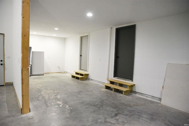 basement featuring stainless steel refrigerator