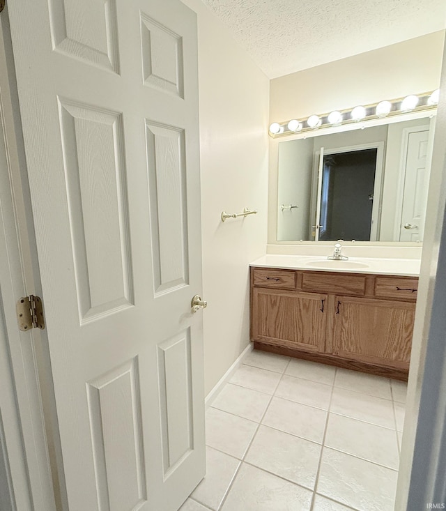 bathroom featuring vanity, tile patterned floors, and a textured ceiling