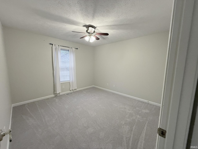 unfurnished room featuring ceiling fan, carpet, and a textured ceiling