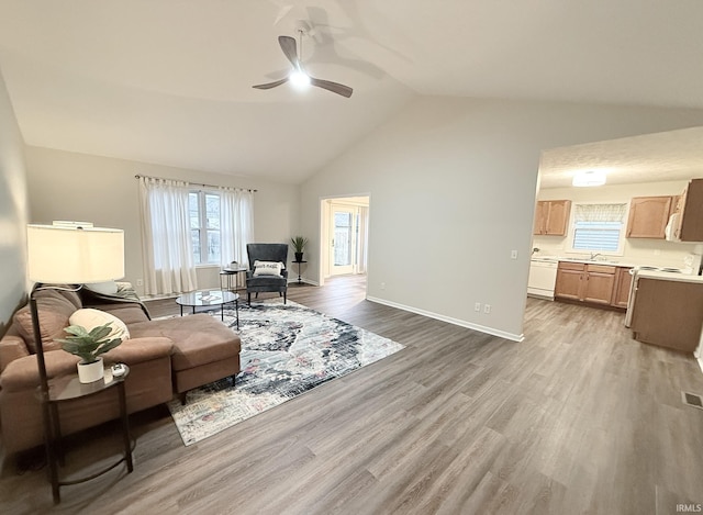 living room with ceiling fan, vaulted ceiling, and hardwood / wood-style flooring