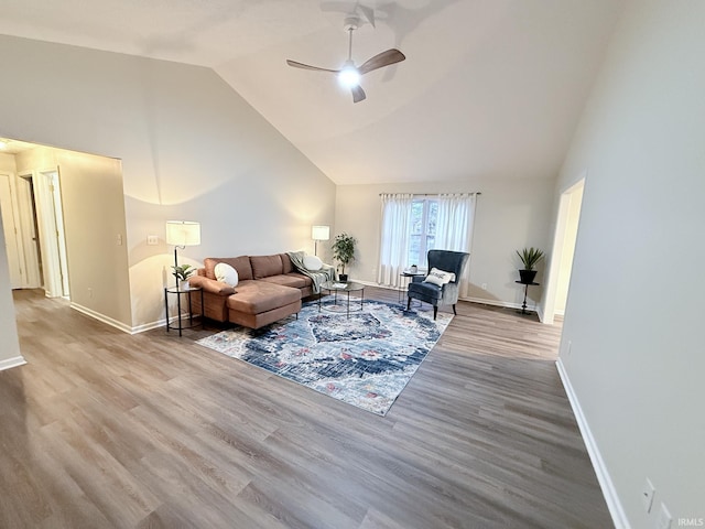 living room with ceiling fan, vaulted ceiling, and hardwood / wood-style floors