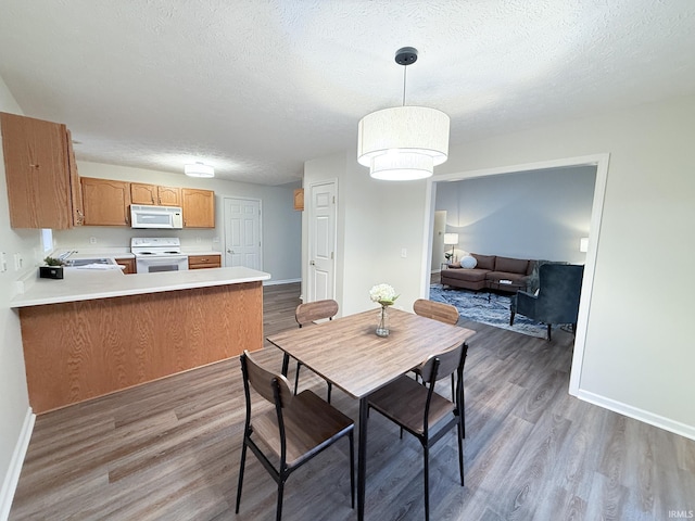 dining space with sink, hardwood / wood-style floors, and a textured ceiling